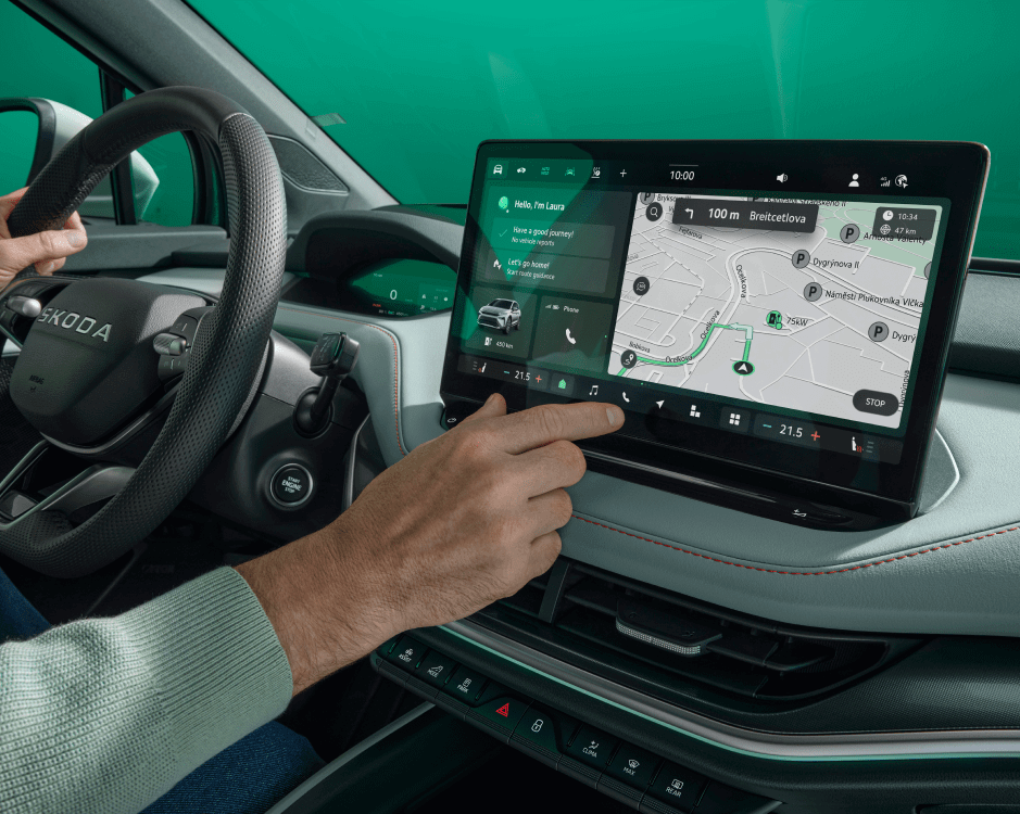 someone holds a finger out towards the car's dashboard screen, which shows a map