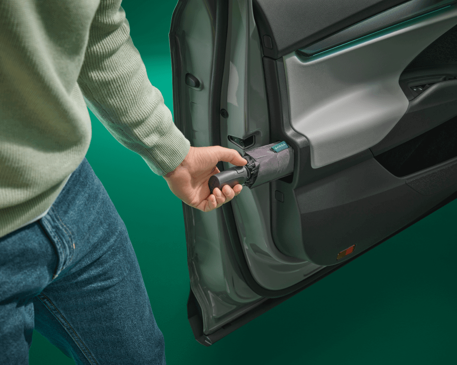 a man takes an umbrella out of a hidden compartment in the car's door